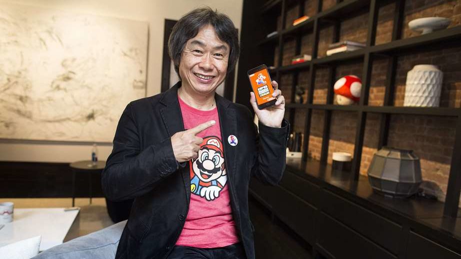 Shigeru Miyamoto subjectant un mòbil intel·ligent mostrant Super Mario Run